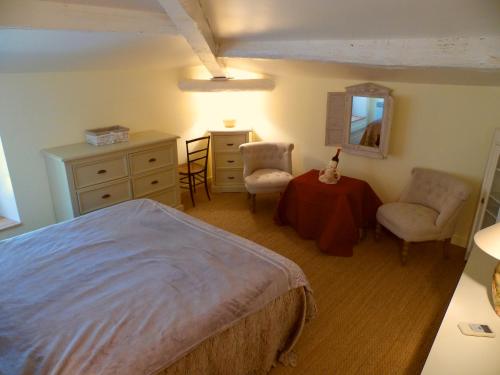 une chambre avec un lit, une table et des chaises dans l'établissement Gîte Belfloret, à Renneville