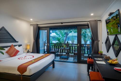 a bedroom with a bed and a desk and a balcony at Khmer Mansion Boutique Hotel in Siem Reap