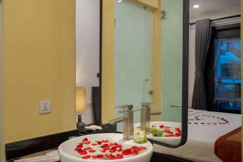 a bathroom with a sink and a mirror and a bed at Khmer Mansion Boutique Hotel in Siem Reap
