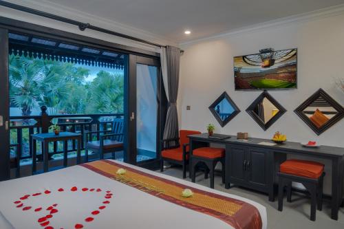 a bedroom with a bed and a table and chairs at Khmer Mansion Boutique Hotel in Siem Reap