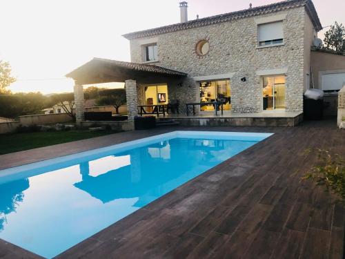 a swimming pool in front of a house at LA BASTIDE DU SOLEIL avec piscine, calme, randonnée à proximité in Allegre Les Fumades