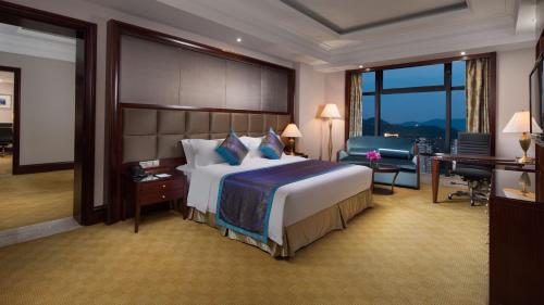a hotel room with a large bed and a desk at Crowne Plaza Deqing Moganshan by IHG in Deqing
