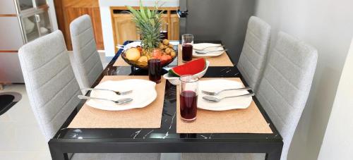 a dining room table with chairs and a table with food on it at Ormoc City Gate 3 in Ormoc