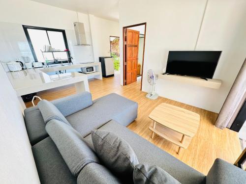 a living room with a couch and a tv at The Scenery Beach Resort in Baan Khai