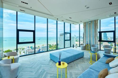 a living room with a blue couch and large windows at Sea View 2 Bed Room At Excellent Location in Pattaya Central