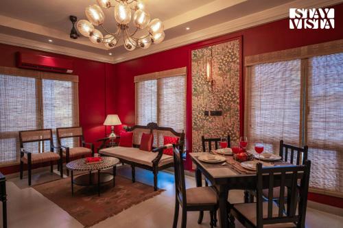 a dining room with red walls and a table and chairs at StayVista at Nayak House with Terrace, Wi-Fi in Kolkata