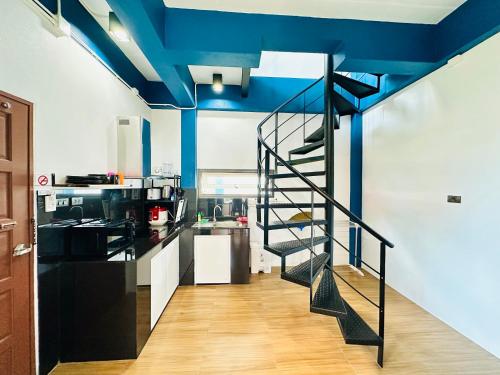 a spiral staircase in a kitchen with blue ceilings at The Scenery Beach Resort in Baan Khai