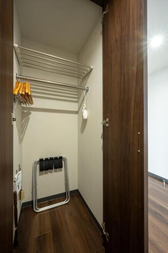 a room with a door and a chair in it at Hotel Maruya Grande in Minamisouma