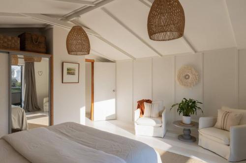 a bedroom with a bed and a couch and a chair at Peaceful Nelson getaway - spa pool, space & views in Nelson