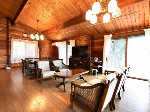 a living room with a table and chairs and a television at ヴィータ牛窓 in Setouchi