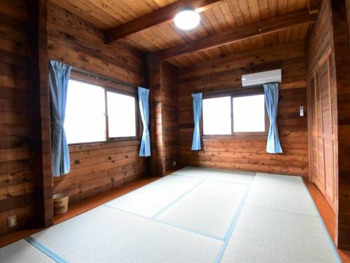 an empty room with two windows in a log cabin at ヴィータ牛窓 in Setouchi