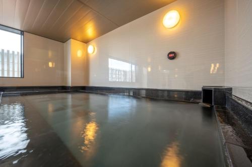 an empty swimming pool in a building with water at Hotel Maruya Grande in Minamisouma