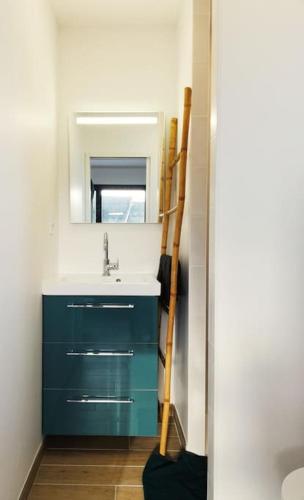 une salle de bain avec un lavabo bleu et un miroir dans l'établissement Studio Mado proche centre ville questembert, à Questembert