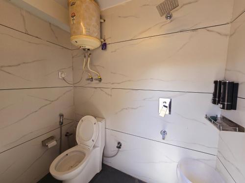 a bathroom with a toilet and a sink at THE BUNK STREET in Manāli