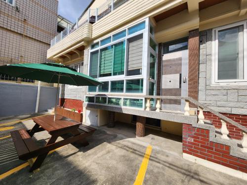 a patio with a table and an umbrella in front of a building at Daemyeongyeok - house of gallery in Daegu