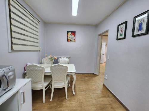 a dining room with a white table and chairs at Daemyeongyeok - house of gallery in Daegu