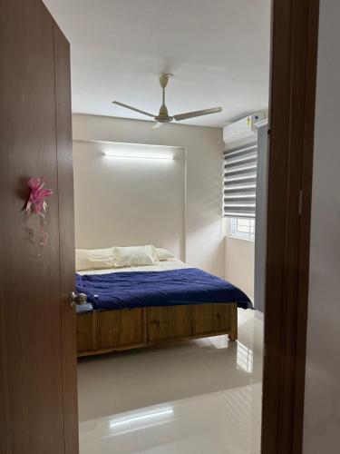 a bedroom with a bed with a ceiling fan at Aami dhivahi guest house 01 in Trivandrum