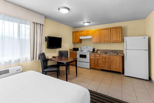 a kitchen with a table and a white refrigerator at Quality Inn & Suites Vancouver - Hazel Dell in Vancouver