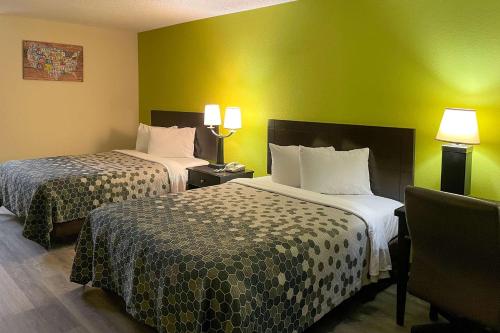 two beds in a hotel room with green walls at Econo Lodge Inn & Suites Sweetwater I-20 in Sweetwater