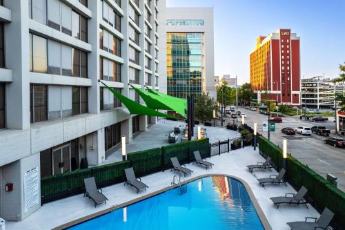 a view of a building with a pool and chairs at Hilton Birmingham Downtown at UAB in Birmingham