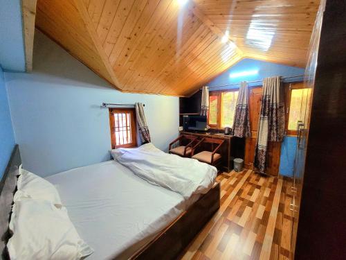 a small bedroom with a bed and a desk at Pine Paradise Homestay in Shimla
