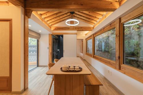 a kitchen with wooden ceilings and windows in a house at Luxury Hanok Seochon Stay in Seoul