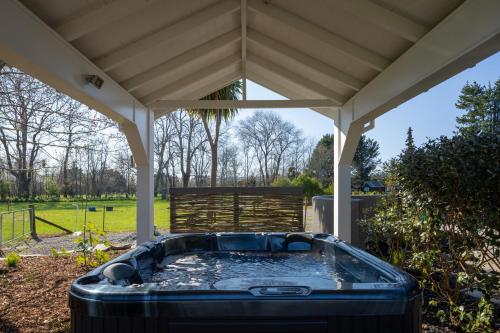 a hot tub under a gazebo at Peaceful Nelson getaway - spa pool, space & views in Nelson