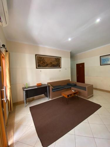 a living room with a couch and a table at Adiputra Guesthouse Tata Bumi by HomiQ in Ngabean