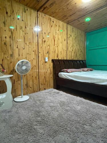 a bedroom with a bed and a wooden wall at ROSIE HOMESTAY Hà Giang in Ha Giang