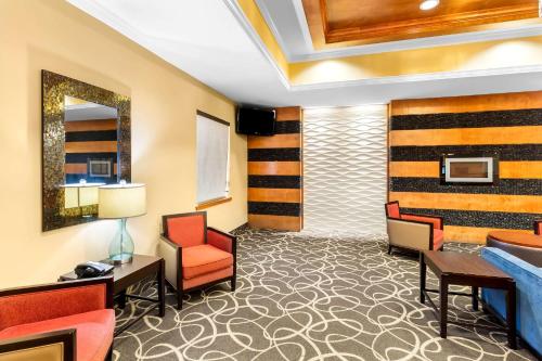 a hotel room with a waiting area with chairs and tables at Comfort Suites at Katy Mills in Katy