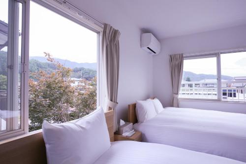浅川にある81 Guest House -ANKI-のベッドが2つあり、大きな窓があるホテルの部屋