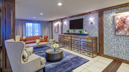 a living room with a couch and a tv at DoubleTree by Hilton Port Huron in Port Huron