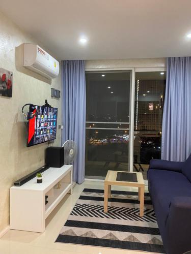 a living room with a blue couch and a tv at Jomtien Second Rd Апартаменты Atlantis in Jomtien Beach