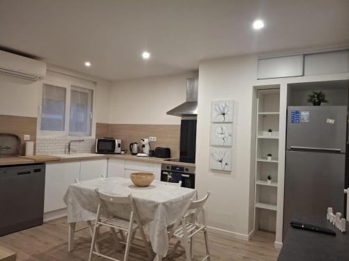 une cuisine avec une table avec des chaises et un réfrigérateur dans l'établissement 3 Pieces Apartment à Juan-les-Pins, à Antibes