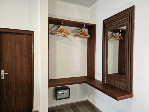 a walk in closet with a mirror and hangers at Garden Rooms by Lagoon View in Bodufolhudhoo