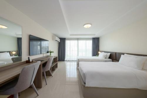 a hotel room with two beds and a desk at SureStay By Best Western Iconic Suvarnabhumi in Samut Prakan