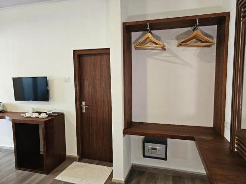 a room with a door and a tv and a desk at Garden Rooms by Lagoon View in Bodufolhudhoo