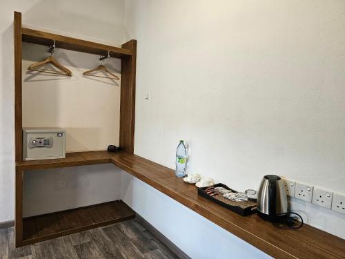 a kitchen with a counter with a sink and a mirror at Garden Rooms by Lagoon View in Bodufolhudhoo