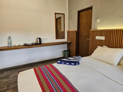 a bedroom with a bed and a mirror on the wall at Garden Rooms by Lagoon View in Bodufolhudhoo