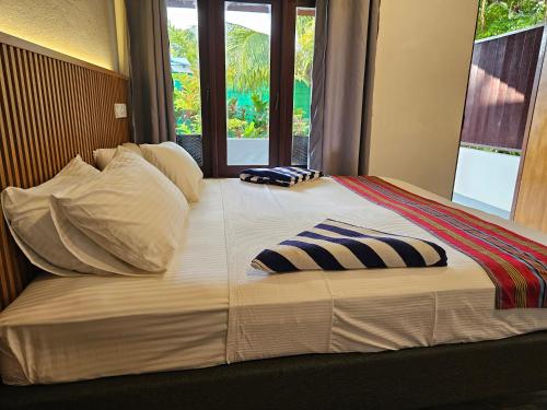 a large bed with two pillows on top of it at Garden Rooms by Lagoon View in Bodufolhudhoo