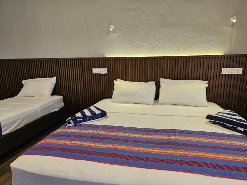 two beds in a hotel room with two bedsvisor at Garden Rooms by Lagoon View in Bodufolhudhoo