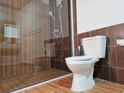a bathroom with a toilet and a shower at Garden Rooms by Lagoon View in Bodufolhudhoo
