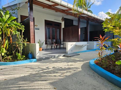 a house with a front porch with a patio at Garden Rooms by Lagoon View in Bodufolhudhoo