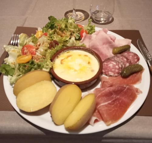 a plate of food with meat and vegetables on a table at CONTACT HOTEL LE BOIS SAUVAGE in Saint-Agrève