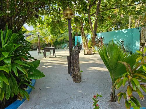 a street light in a park with trees and plants at Garden Rooms by Lagoon View in Bodufolhudhoo