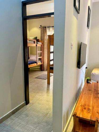 a hallway with a table and a room with a bunk bed at Moshi Epic Accommodation in Moshi
