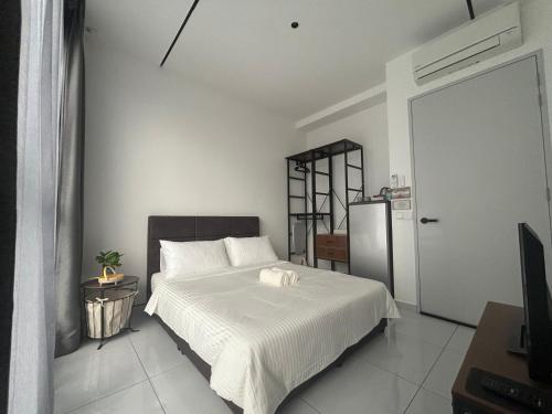 a bedroom with a white bed and a refrigerator at Skytrees Comfort Room With Simple Design Concept in Johor Bahru