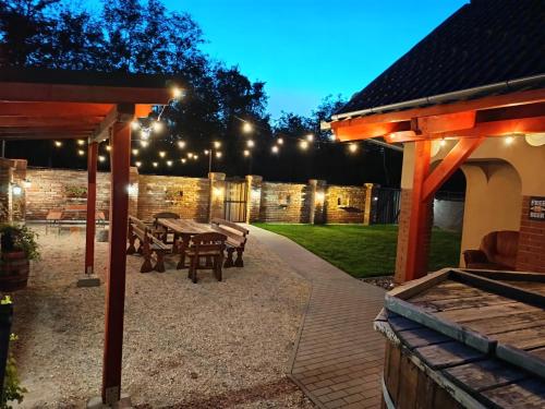 patio w nocy ze stołem i ławkami w obiekcie Gyopárosi Vendégház w mieście Gyopárhalom