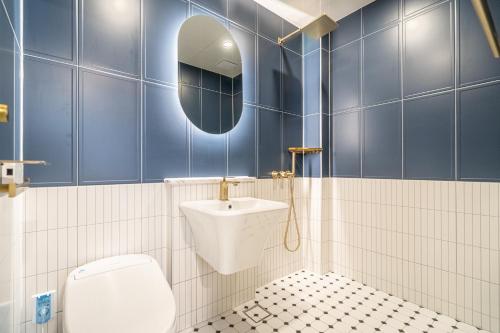 a bathroom with a toilet and a sink and a mirror at Browndot hotel Gimhae cityhall in Gimhae