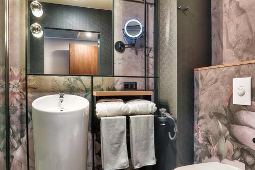a bathroom with a sink and a toilet and a mirror at Focus Hotel Premium Warszawa in Warsaw